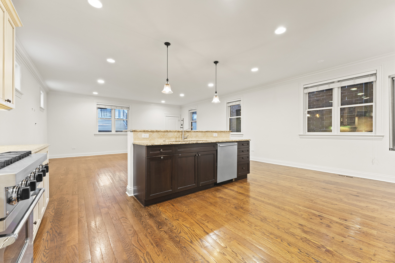3716 North Kenmore Avenue, Unit 1 Chicago, IL 60613 - Photo 7 of 26 a large kitchen with stainless steel appliances granite countertop a sink a stove and a wooden floors