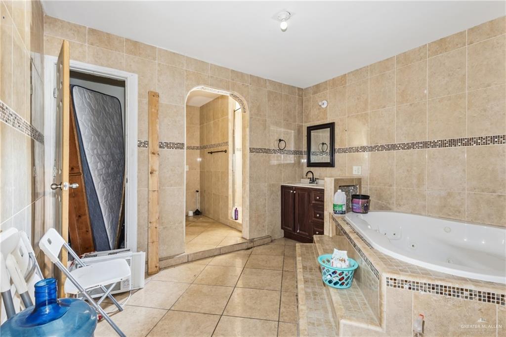 335 Watts Avenue Weslaco, TX 78596 - Photo 15 of 15 a bathroom with a tub a sink and a large mirror