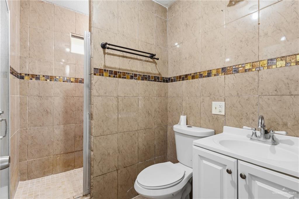 335 Watts Avenue Weslaco, TX 78596 - Photo 9 of 15 a bathroom with a sink a toilet and shower