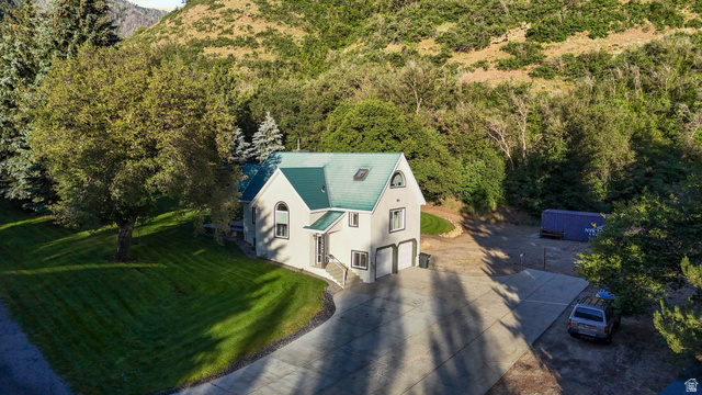 10686 South Covered Brg Cyn Road, Unit 14 Spanish Fork, UT 84660 - Photo 19 of 44 Two-story residence with a prominent green roof, featuring a two-car garage, arched windows, and a concrete driveway