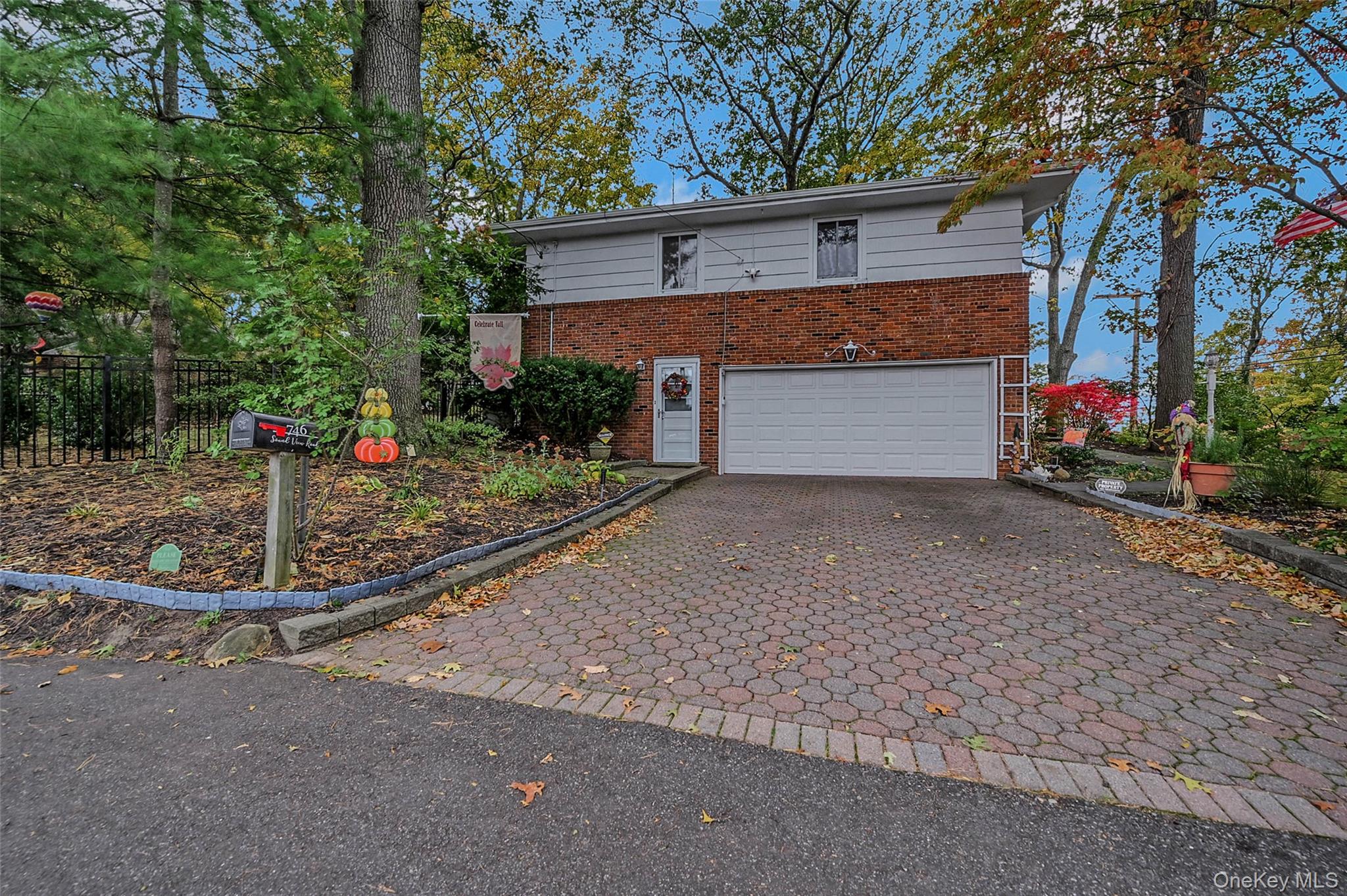 746 Sound View Road Mill Neck, NY 11765 - Photo 4 of 37 a front view of a house with a yard and garage