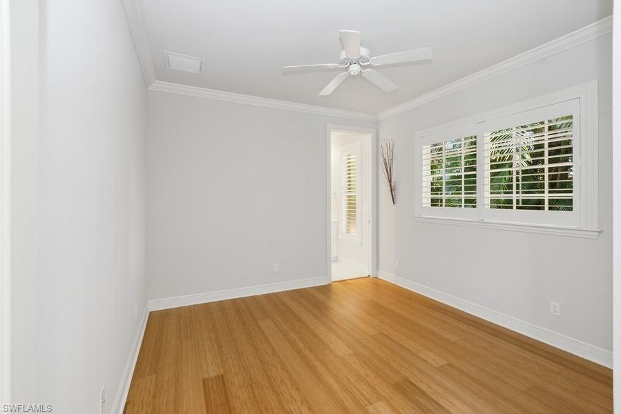 502 Cormorant Cove Naples, FL 34113 - Photo 18 of 25 an empty room with wooden floor fan and windows