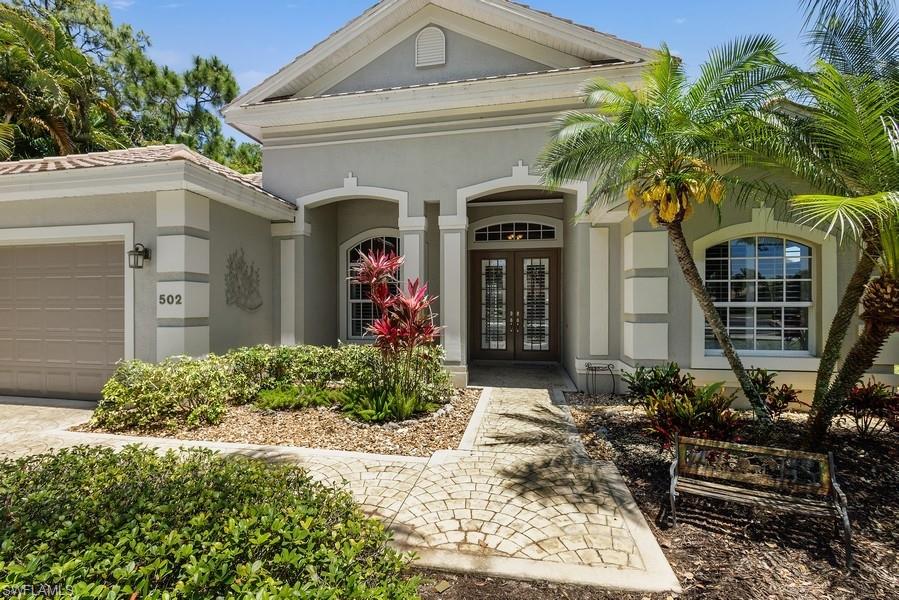 502 Cormorant Cove Naples, FL 34113 - Photo 2 of 25 a front view of a house with garden