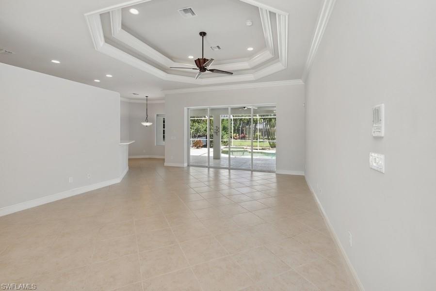 502 Cormorant Cove Naples, FL 34113 - Photo 4 of 25 an empty room with wooden floor and ceiling fan