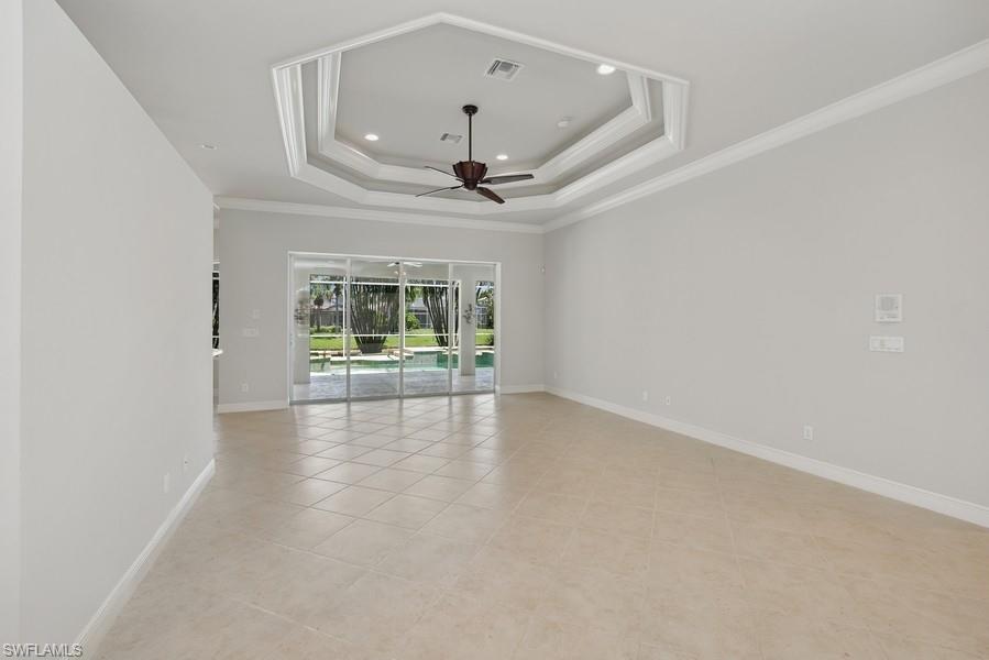 502 Cormorant Cove Naples, FL 34113 - Photo 5 of 25 an empty room with ceiling fan and windows