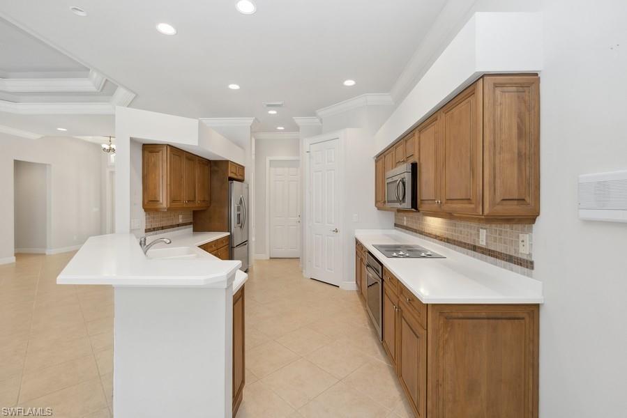 502 Cormorant Cove Naples, FL 34113 - Photo 8 of 25 a kitchen with stainless steel appliances granite countertop a sink and a stove