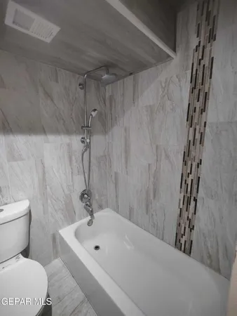 a bathroom with a granite countertop toilet and a sink