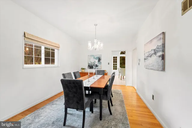 a dining room with furniture a chandelier and wooden floor