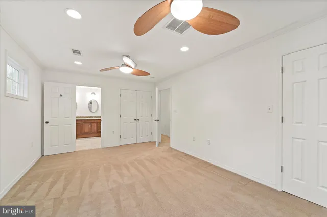 an empty room with cabinet and windows