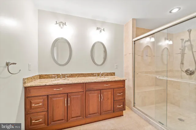 a bathroom with a granite countertop sink mirror and a shower
