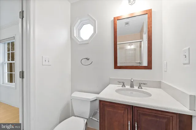 a bathroom with a sink toilet and mirror