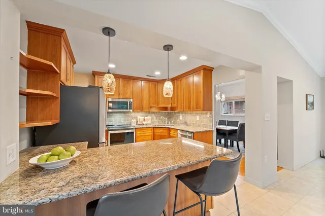 a kitchen with granite countertop a table chairs and wooden floor
