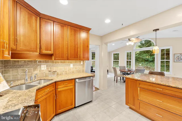 a large kitchen with kitchen island granite countertop a large window and a sink