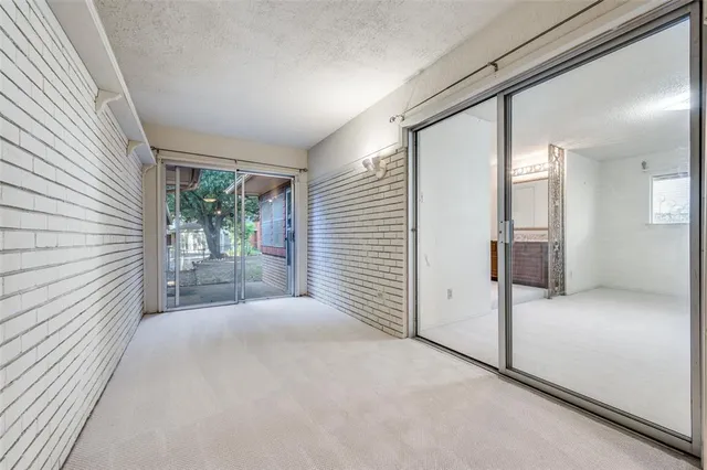 a view of a hallway with wooden floor and a bathroom