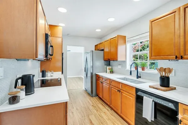 a kitchen with a sink a counter top space and stainless steel appliances