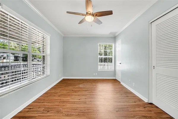 a view of an empty room with a window and wooden floor