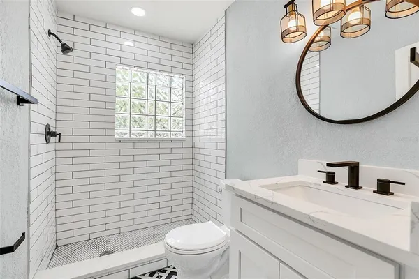a bathroom with a toilet sink vanity and mirror