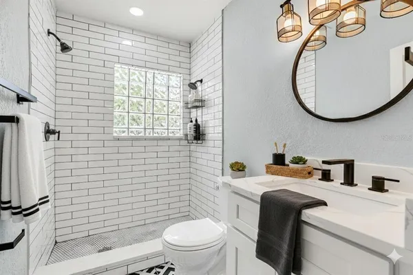 a bathroom with a toilet sink vanity and mirror