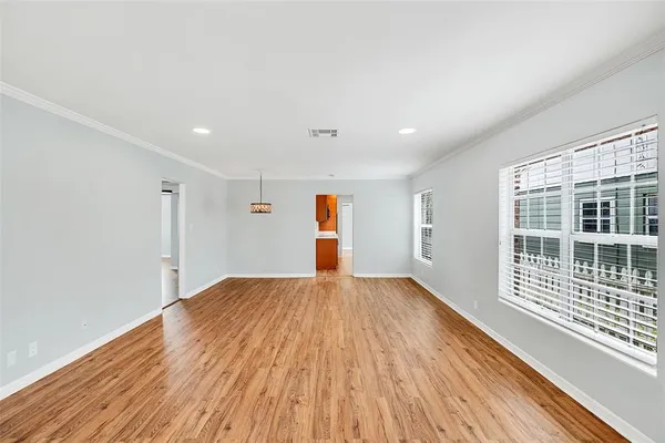 a view of empty room with wooden floor and fence