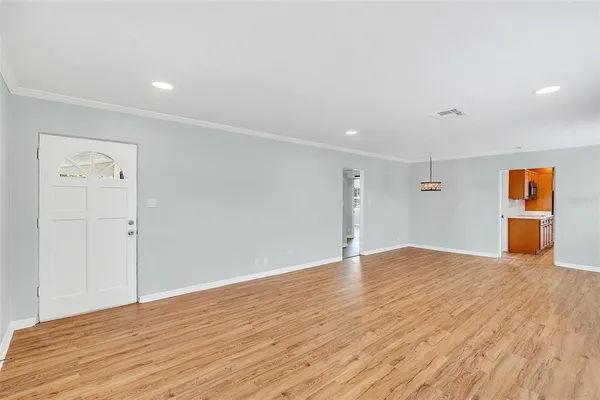 a view of an empty room with wooden floor
