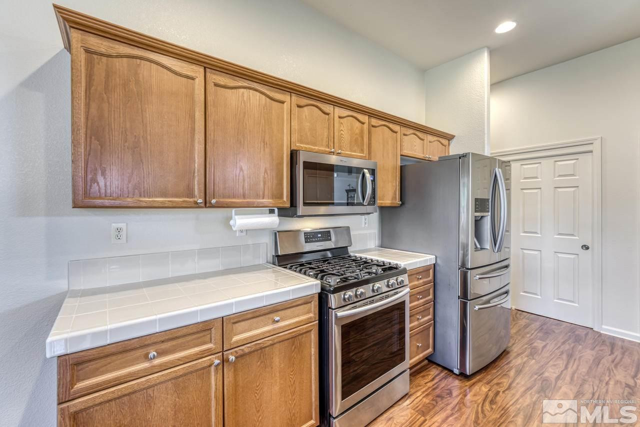 10395 Canyon Country Road Reno, NV 89521 - Photo 17 of 31 a kitchen with granite countertop a refrigerator stove and microwave