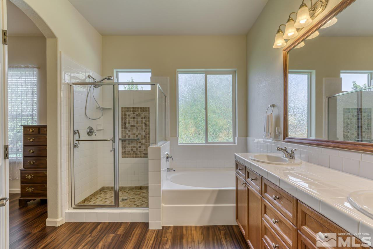 10395 Canyon Country Road Reno, NV 89521 - Photo 23 of 31 a bathroom with a granite countertop sink a mirror and shower