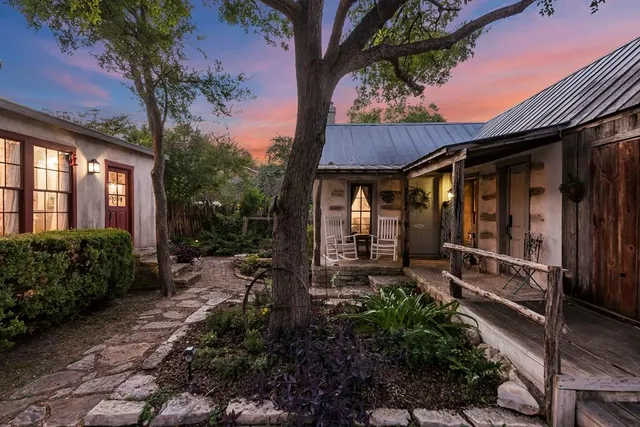 a view of a patio with table and chairs potted plants and floor to ceiling window