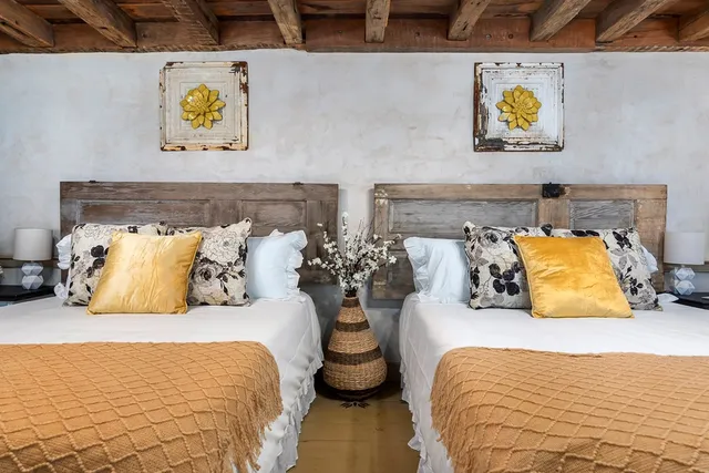 a bedroom with a bed and painting on the wall