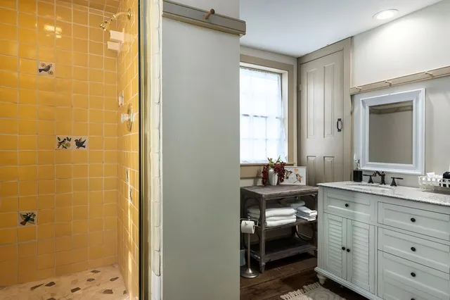 a bathroom with a double vanity sink a mirror and next to a window