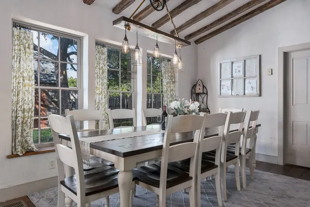 a dining room with furniture large windows and wooden floor