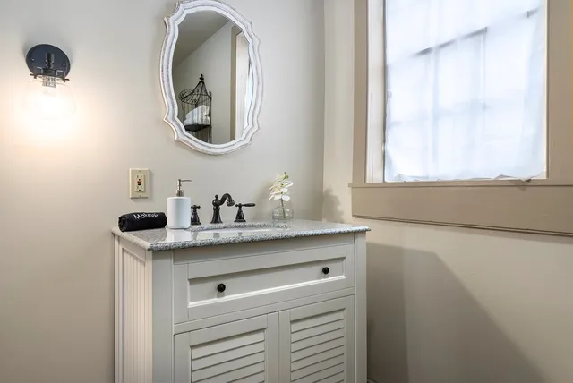 a bathroom with a granite countertop sink and a mirror