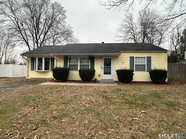 a front view of house with yard and trees around