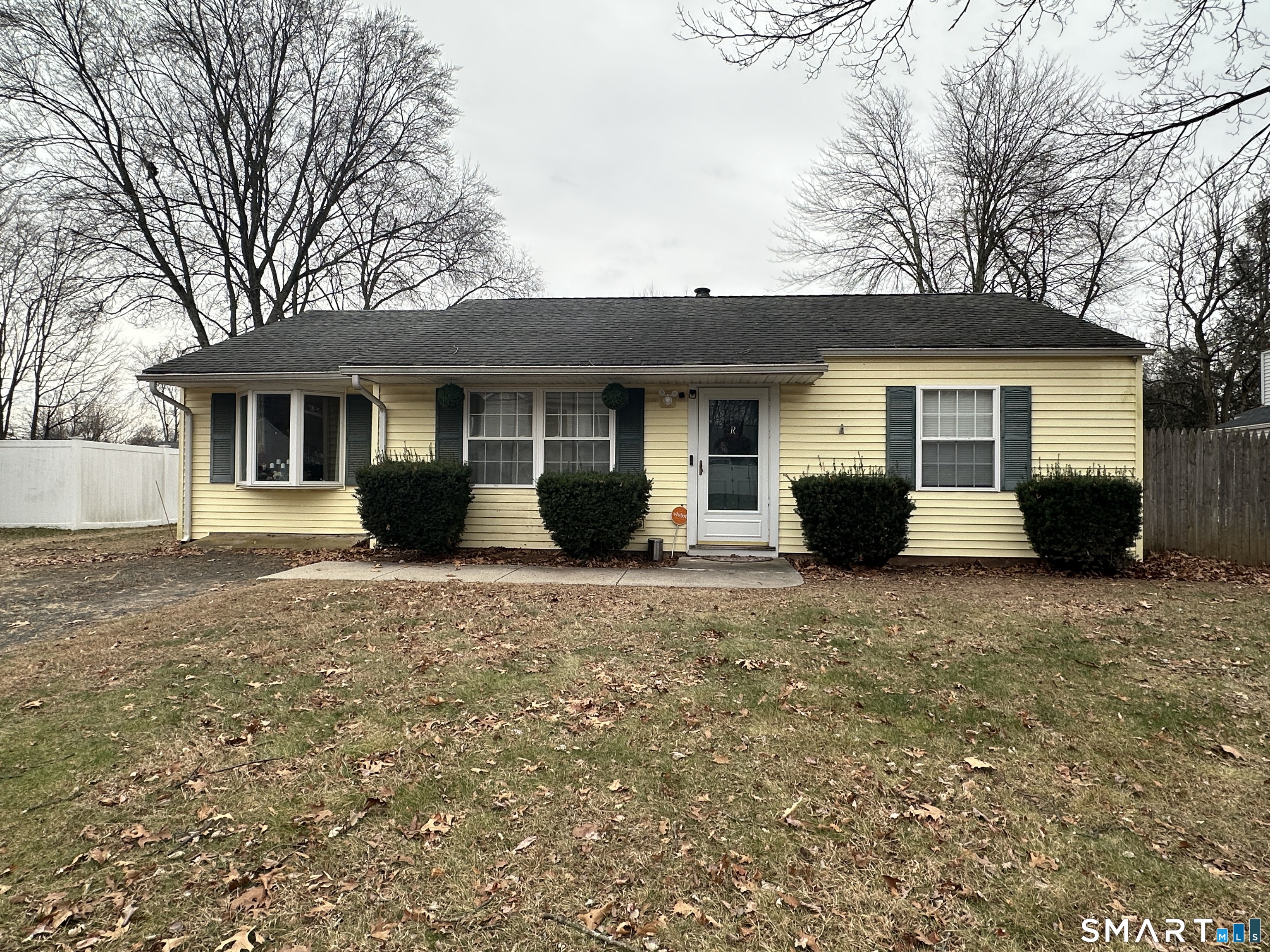 a front view of house with yard and trees around