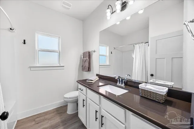 a kitchen with stainless steel appliances granite countertop a stove a sink a dining table and chairs with wooden floor