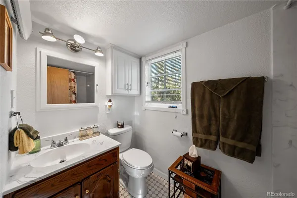 a bathroom with a sink toilet and mirror