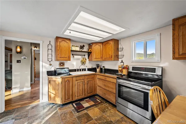 a kitchen with stainless steel appliances granite countertop a stove a sink and a refrigerator
