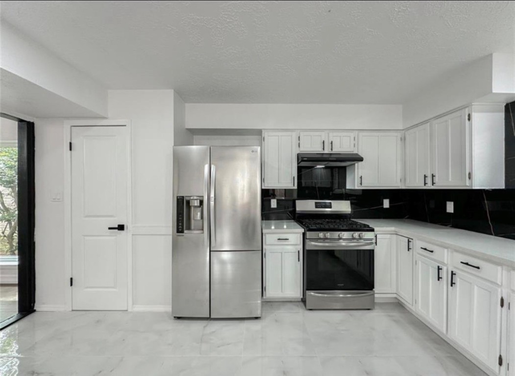 7311 Fuchsia Lane Humble, TX 77346 - Photo 11 of 38 a kitchen with stainless steel appliances granite countertop a refrigerator and a stove top oven