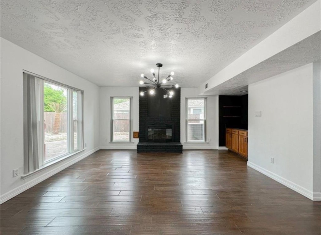 7311 Fuchsia Lane Humble, TX 77346 - Photo 12 of 38 an empty room with wooden floor chandelier and windows