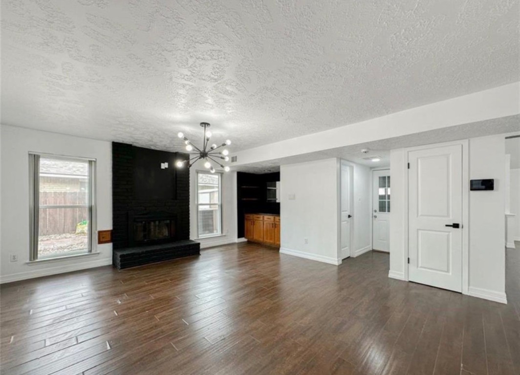 7311 Fuchsia Lane Humble, TX 77346 - Photo 13 of 38 an empty room with wooden floor chandelier and windows