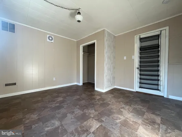 an empty room with windows and closet