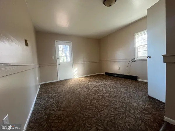 an empty room with hard wood floor and window