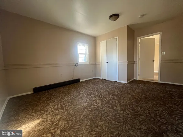 an empty room with wooden floor and a window