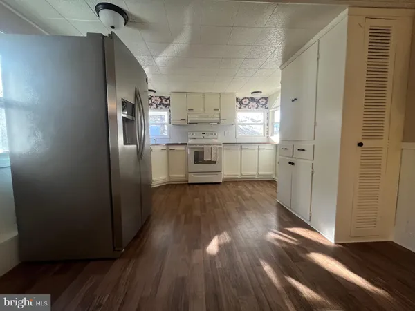 a kitchen with kitchen island wooden floors appliances and cabinets