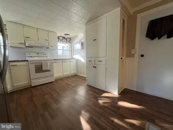 a kitchen with a white stove top oven and white cabinets