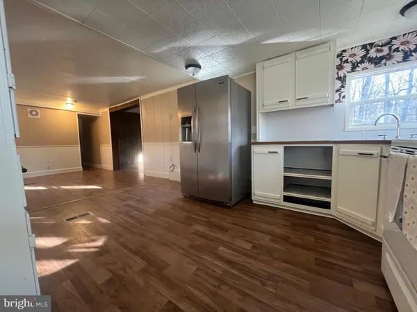 a view of a refrigerator in kitchen and wooden floor