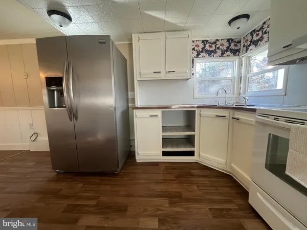 a kitchen with stainless steel appliances cabinets and a wooden floor