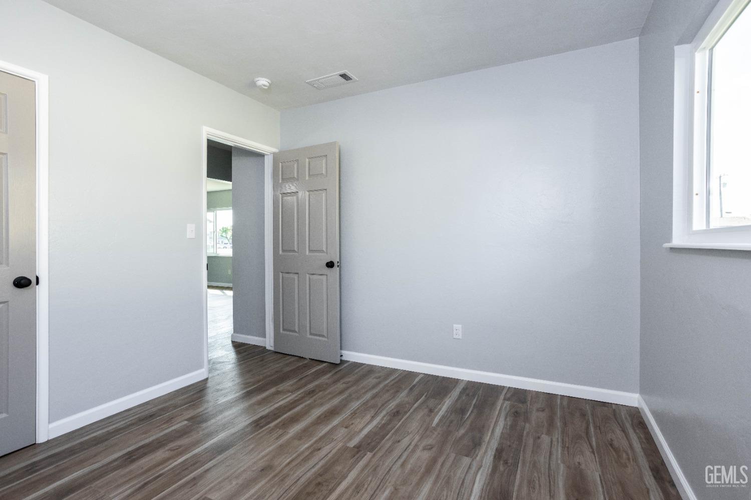 Undisclosed Address Shafter, CA 93263 - Photo 15 of 18 an empty room with wooden floor and windows