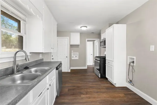 a kitchen with kitchen island a sink appliances and cabinets