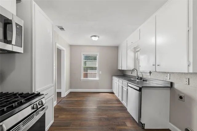 a kitchen with stainless steel appliances a stove sink and cabinets