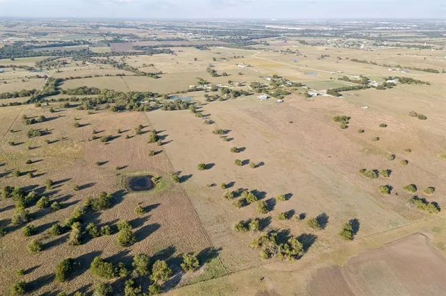 an aerial view of ocean and residential houses with outdoor space
